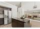 Open kitchen featuring a center island, stainless steel refrigerator, and views into the dining area at 13724 W Luke Ave, Litchfield Park, AZ 85340