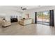 Bright living room with wood-look floors, a large sectional sofa, and backyard access at 13724 W Luke Ave, Litchfield Park, AZ 85340
