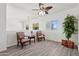 Cozy upstairs loft space with two chairs, a table, a ceiling fan, and natural light at 13724 W Luke Ave, Litchfield Park, AZ 85340