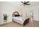 Spacious main bedroom featuring a ceiling fan, hardwood floors, and a large bed with decorative pillows at 13724 W Luke Ave, Litchfield Park, AZ 85340