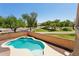 Inviting backyard pool with lush landscaping and a view of the community playground at 13724 W Luke Ave, Litchfield Park, AZ 85340