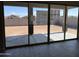 View of the backyard through sliding glass doors with large gray paver patio at 16035 W Questa Dr, Surprise, AZ 85387
