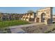 Stone entryway featuring manicured landscaping and a pergola-covered walkway welcomes residents at 16035 W Questa Dr, Surprise, AZ 85387