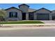 Charming single-story home featuring desert landscaping, a two-car garage, and a stone-accented facade at 16035 W Questa Dr, Surprise, AZ 85387