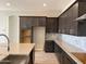 Modern kitchen with large island, stainless steel faucet, and stylish brown cabinetry at 16035 W Questa Dr, Surprise, AZ 85387