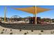 Community playground with shade structure, various play equipment, and seating areas at 16035 W Questa Dr, Surprise, AZ 85387