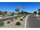 Scenic street view with new trees and landscaping along a paved road in a modern community at 16035 W Questa Dr, Surprise, AZ 85387
