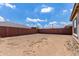 Spacious dirt backyard surrounded by a brick wall and clear blue skies with fluffy white clouds at 16221 W Prickly Pear Trl, Surprise, AZ 85387