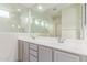 Modern bathroom with dual sinks, gray cabinetry, and a large mirror reflecting a walk-in shower at 16221 W Prickly Pear Trl, Surprise, AZ 85387