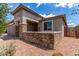 Charming home exterior featuring stone accents and desert-friendly gravel landscaping for easy maintenance at 16221 W Prickly Pear Trl, Surprise, AZ 85387