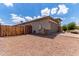 Home's exterior features a two-car garage, gravel landscaping, and a wooden fence at 16221 W Prickly Pear Trl, Surprise, AZ 85387
