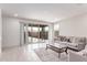 Bright living room featuring neutral walls, tile flooring, and sliding glass doors that open to the backyard at 16221 W Prickly Pear Trl, Surprise, AZ 85387