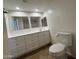 Well-lit bathroom featuring an extended vanity with white cabinets and a modern toilet at 1714 W Villa Rita Dr, Phoenix, AZ 85023