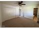 This is a spacious bedroom with neutral carpeting, a ceiling fan, and a double-door closet at 1714 W Villa Rita Dr, Phoenix, AZ 85023