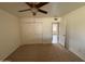 This is a spacious bedroom with neutral carpeting, a ceiling fan, and a double-door closet at 1714 W Villa Rita Dr, Phoenix, AZ 85023