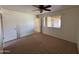 This is a spacious bedroom with neutral carpeting, a ceiling fan, and a double-door closet at 1714 W Villa Rita Dr, Phoenix, AZ 85023