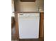 White Kenmore dishwasher with wooden cabinetry and tile flooring at 1714 W Villa Rita Dr, Phoenix, AZ 85023