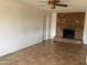 Bright living room featuring a brick fireplace, tile flooring, and fresh paint at 1714 W Villa Rita Dr, Phoenix, AZ 85023
