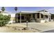 Mobile home exterior with desert landscaping, covered carport, and a quaint front entryway at 17200 W Bell Rd # 47, Surprise, AZ 85374