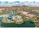 Community aerial view highlighting a resort-style pool, clubhouse, and serene lake with mountain views at 17886 W Brookwood Dr, Goodyear, AZ 85338