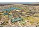 Stunning aerial view of community center, pool, tennis courts, and lake surrounded by meticulously planned homes at 17886 W Brookwood Dr, Goodyear, AZ 85338