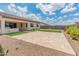 Extended stone patio with a patch of artificial turf and low-maintenance desert landscaping, perfect for outdoor entertaining at 17886 W Brookwood Dr, Goodyear, AZ 85338