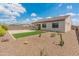 Spacious backyard with desert landscaping, artificial grass, covered patio, and block fencing, perfect for outdoor living at 17886 W Brookwood Dr, Goodyear, AZ 85338