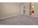 Comfortable carpeted bedroom with neutral paint and a view into the ensuite bathroom at 17886 W Brookwood Dr, Goodyear, AZ 85338