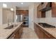 Modern kitchen featuring stainless steel appliances, granite countertops, and dark wood cabinets at 17886 W Brookwood Dr, Goodyear, AZ 85338