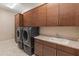Functional laundry room featuring modern washer and dryer, ample cabinetry, and a sink at 17886 W Brookwood Dr, Goodyear, AZ 85338