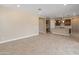 Open-concept living space with tile flooring flowing into the kitchen and dining area at 17886 W Brookwood Dr, Goodyear, AZ 85338