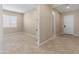 Open-concept living room with view to entry featuring neutral paint and tile flooring at 17886 W Brookwood Dr, Goodyear, AZ 85338