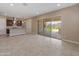 Bright and open living room with neutral paint, tile flooring, and sliding glass doors leading to the backyard at 17886 W Brookwood Dr, Goodyear, AZ 85338