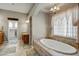 Luxurious bathroom with a jetted tub, tile surround, and ample natural light at 21384 E Excelsior Ave, Queen Creek, AZ 85142