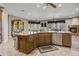 Open kitchen and living area featuring stone fireplace, stainless steel appliances, and tiled flooring at 21384 E Excelsior Ave, Queen Creek, AZ 85142