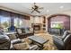 Relaxing living room with a fireplace, comfortable seating, and a view into the backyard, creating a cozy atmosphere at 21384 E Excelsior Ave, Queen Creek, AZ 85142