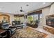Spacious living room featuring a fireplace, comfortable seating, and large windows overlooking the backyard at 21384 E Excelsior Ave, Queen Creek, AZ 85142