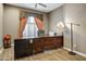A home office with wooden desk, cabinets, chair and lamp at 21384 E Excelsior Ave, Queen Creek, AZ 85142