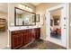 Bathroom features a double sink vanity, decorative mirrors, stylish fixtures and an exterior door to the patio at 2171 E Iris Dr, Chandler, AZ 85286