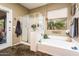 Bathroom features a soaking tub, glass shower, decor, and natural light from the window at 2171 E Iris Dr, Chandler, AZ 85286