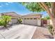 Close-up of a three-car garage with tiled roof, framed by a large tree and lush landscaping at 2171 E Iris Dr, Chandler, AZ 85286