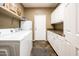 Efficient laundry room with white cabinets, folding counter and washer and dryer hookups at 2171 E Iris Dr, Chandler, AZ 85286