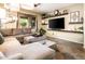 Cozy living room featuring a sectional sofa, decorative shelves, and natural light at 2171 E Iris Dr, Chandler, AZ 85286