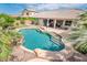 Beautiful pool with water feature surrounded by a patio, tropical plants, and a grassy area at 2171 E Iris Dr, Chandler, AZ 85286