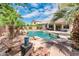 Backyard featuring a private pool, patio, and a rock water feature surrounded by lush tropical landscaping at 2171 E Iris Dr, Chandler, AZ 85286