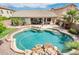 Inviting backyard oasis with a pool, patio, and a built-in water feature surrounded by tropical landscaping at 2171 E Iris Dr, Chandler, AZ 85286