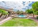 Backyard pool with rock waterfall feature and lush landscaping from the lawn at 2171 E Iris Dr, Chandler, AZ 85286
