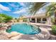 Refreshing pool surrounded by palm trees, tropical landscaping, and a covered patio at 2171 E Iris Dr, Chandler, AZ 85286