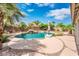 Lush backyard features a private pool, rock waterfall, palm trees, a patio, and desert landscaping at 2171 E Iris Dr, Chandler, AZ 85286