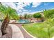 Palm trees surround this backyard pool with a rock waterfall feature at 2171 E Iris Dr, Chandler, AZ 85286